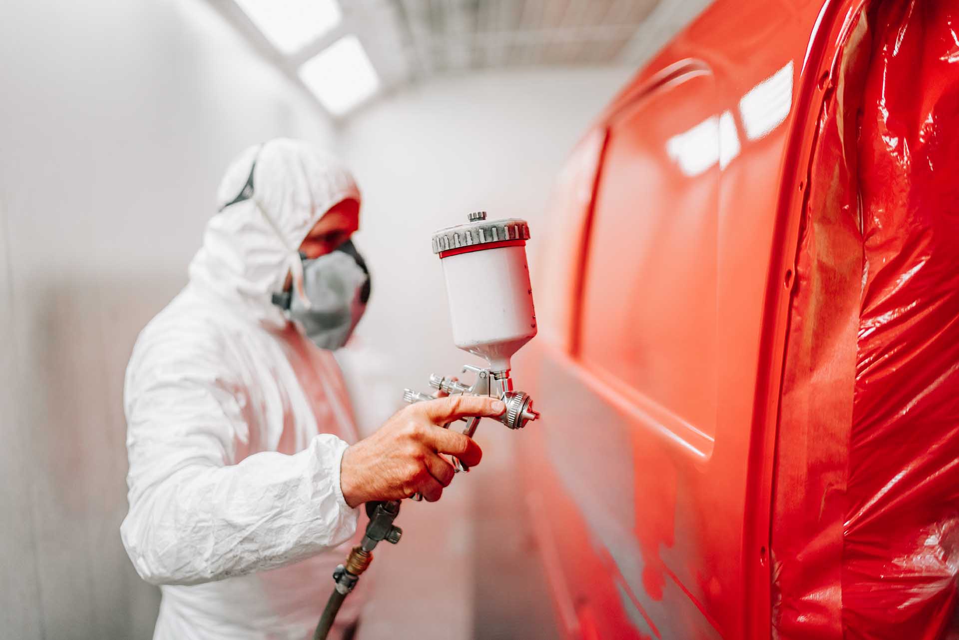 Worker Painting A Car Using A Paint Spray Gun L6FHL8Z Resize 
